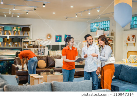 couple customer chat with a store employee looking at catalog with tablet 110947314