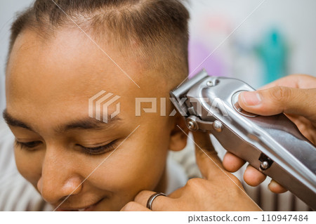 asian male customer getting hair cut in barbershop cropped view 110947484