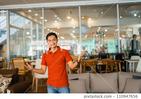 male shop assistant in red with an excited expression in furniture store male shop assistant in red with an excited expression in furniture store 110947656