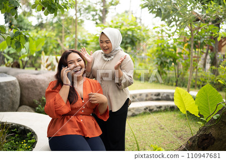 hijab woman support her friend that talking on a phone hijab woman support her friend that talking on a phone 110947681