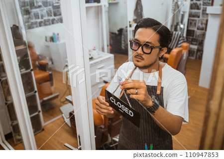 asian barber wearing apron holding closed sign asian barber wearing apron holding closed sign 110947853