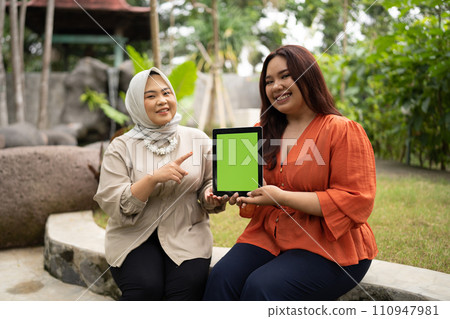 businesswoman holding green screen tablet when sitting in outdoor cafe businesswoman holding green screen tablet when sitting in outdoor cafe 110947981