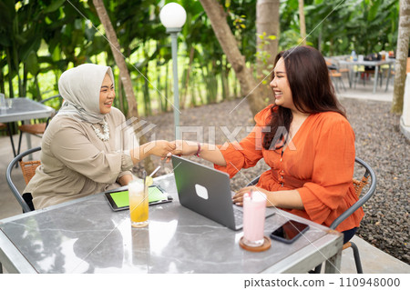hijab woman handshake with her work colleague in a cafe 110948000