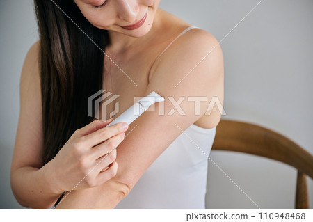 A woman in her 30s shaving her arm hair with an electric shaver 110948468