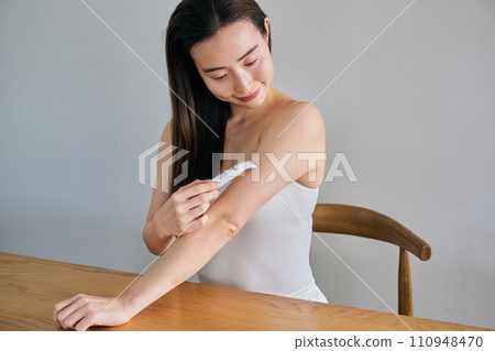 一名30多歲的女士用電動刮鬍刀剃手臂毛 110948470