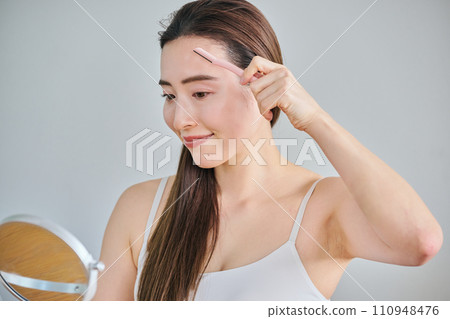 一名 30 多歲的女性用女士刮鬍刀刮臉 一名 30 多歲的女性用女士刮鬍刀刮臉 110948476