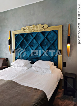 Elegant boutique hotel room with modern sconces and luxury bedding 110948531