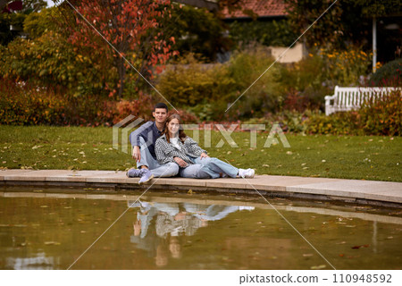 Young couple kissing and rejoices at the lake. lovely young couple kissing outdoors in autumn. Loving couple walking in nature. Autumn mood. Happy man and woman hugging and kissing in autumn. Love Young couple kissing and rejoices at the lake. lovely young couple kissing outdoors in autumn. Loving couple walking in nature. Autumn mood. Happy man and woman hugging and kissing in autumn. Love 110948592