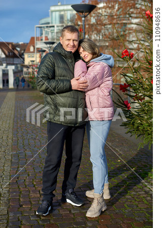 Portrait of young attractive people, lovely couple enjoying cozy atmosphere on fair in Christmas Eve. Spending time together. Concept of national traditions, winter holidays, fashion, festivities Portrait of young attractive people, lovely couple enjoying cozy atmosphere on fair in Christmas Eve. Spending time together. Concept of national traditions, winter holidays, fashion, festivities 110948636