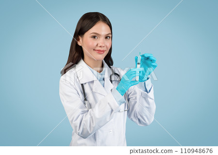 Friendly woman doctor in white coat with syringe 110948676