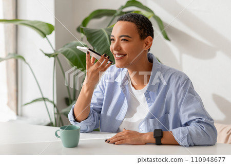 Content professional engages in pleasant conversation on mobile phone, with smartwatch 110948677