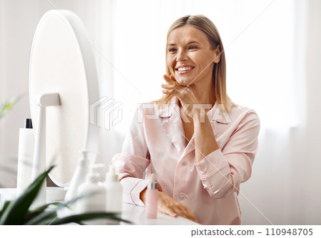 Beautiful mature woman admiring her reflection in the mirror 110948705
