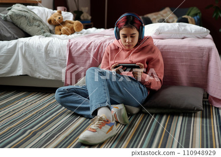 Girl looking at phone screen in gamepad 110948929