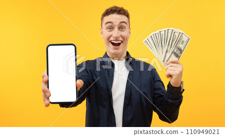 Excited young guy holding big smartphone with white blank screen 110949021