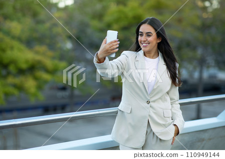 Arabic businesswoman making video call on smartphone gadget standing outside Arabic businesswoman making video call on smartphone gadget standing outside 110949144