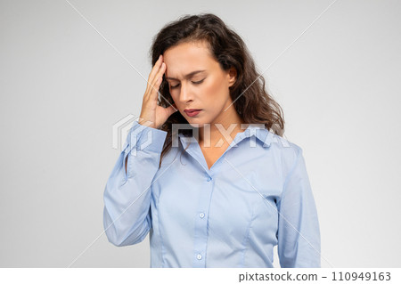 Despaired young european businesswoman, with pained expression, touch forehead 110949163