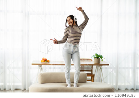 Happy young pretty arab woman in wireless headphones listen music, enjoy spare time Happy young pretty arab woman in wireless headphones listen music, enjoy spare time 110949183