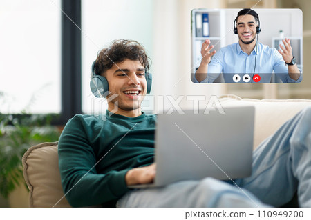 Arabic Guy Have Video Call On Laptop Wearing Earphones Indoors 110949200