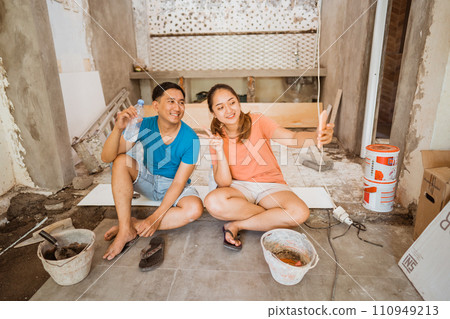 young couple sits down to take a selfie using a cell phone young couple sits down to take a selfie using a cell phone 110949213