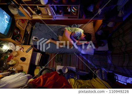 Girl in sleep wear napping on single bed Girl in sleep wear napping on single bed 110949226