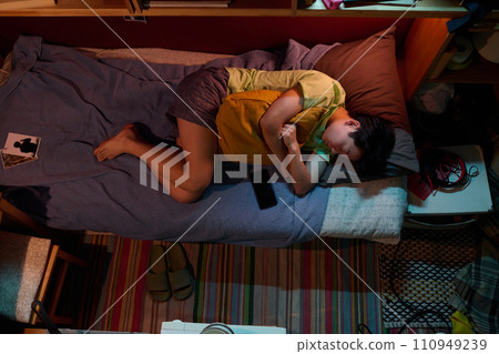 Girl with pillow sleeping on single bed Girl with pillow sleeping on single bed 110949239