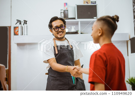 asian male barber greeting his client doing hand shake gesture 110949620