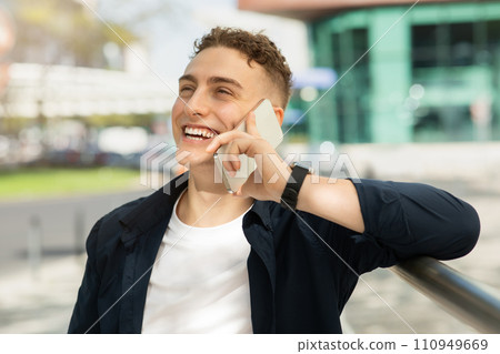 Laughing handsome young european guy enjoy good news, success business, calling 110949669