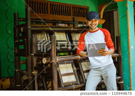 young Asian man bamboo handicraft entrepreneur using tablet 110949678