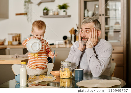 Shocked man looking at his baby son 110949767