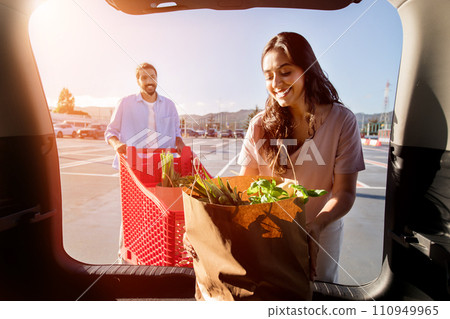 Woman unpacking groceries, man with cart 110949965