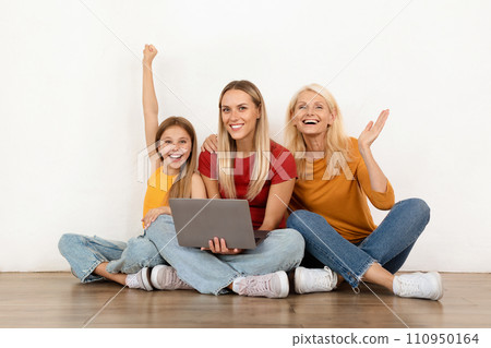 Beautiful family mother, grandmother, daughter using laptop, white wall background 110950164