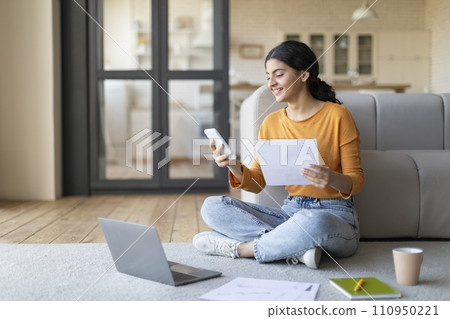 Young Indian Female Working With Laptop And Smartphone At Home Young Indian Female Working With Laptop And Smartphone At Home 110950221