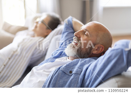 Happy Relaxed Senior Spouses Leaning Back On Comfortable Couch Happy Relaxed Senior Spouses Leaning Back On Comfortable Couch 110950224
