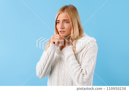 Young lady with throat pain, coughing, blue background 110950238
