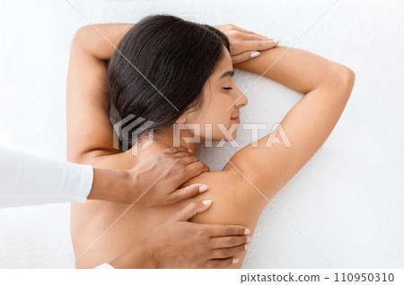 Beautiful naked woman getting relaxing back massage, view above 110950310