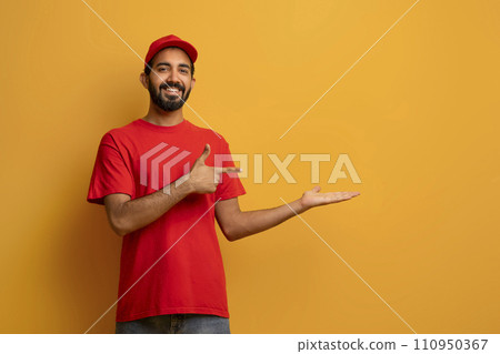 Indian delivery guy in uniform smiling and pointing to his open palm Indian delivery guy in uniform smiling and pointing to his open palm 110950367