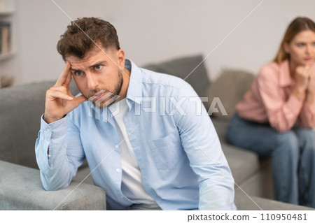 unhappy man turns away from his wife partner at home unhappy man turns away from his wife partner at home 110950481