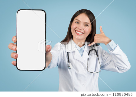 Female medic in white coat, call me gesture and blank phone screen 110950495