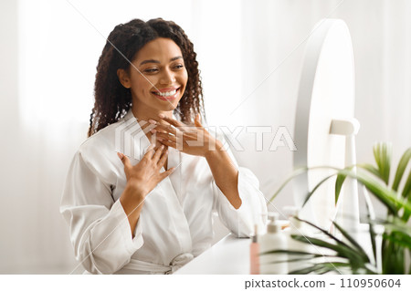 Beauty Care. Beautiful Black Woman Touching Neck Skin And Looking In Mirror 110950604