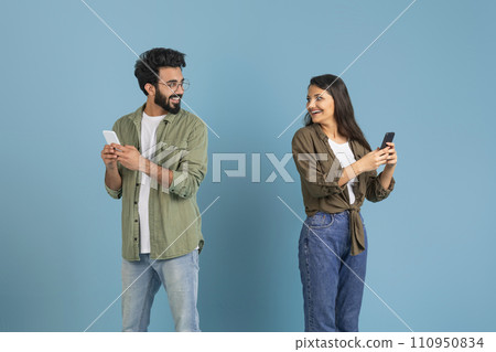 Man and woman using phones and looking at each other 110950834