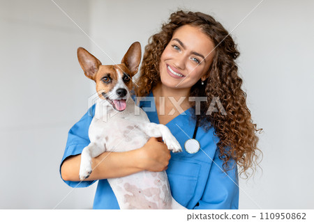 Happy vet holding terrier in clinic Happy vet holding terrier in clinic 110950862