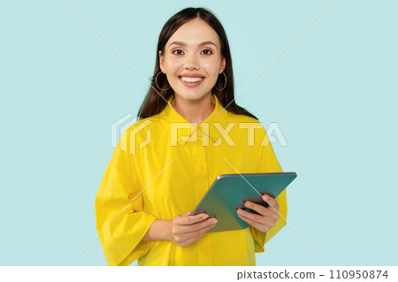 Happy young lady with tablet in hands smiling at camera Happy young lady with tablet in hands smiling at camera 110950874
