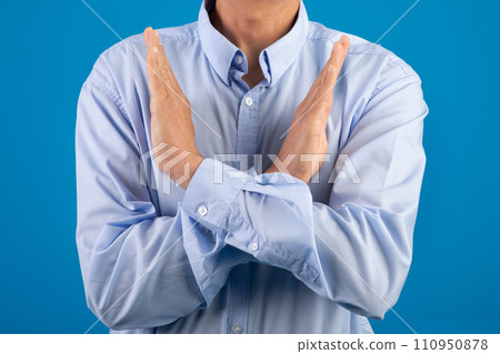 unrecognizable man making cross hands gesture over blue studio background 110950878