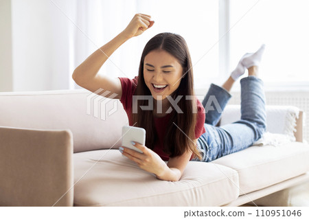 Good News. Joyful Young Asian Woman Celebrating Success With Smartphone At Home 110951046