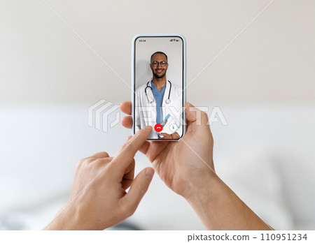 Man at home using smartphone for an online health consultation with doctor Man at home using smartphone for an online health consultation with doctor 110951234