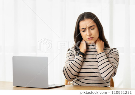 Sad tired young arab woman work at computer, suffer from pain in neck, health problems, feeling bad 110951251