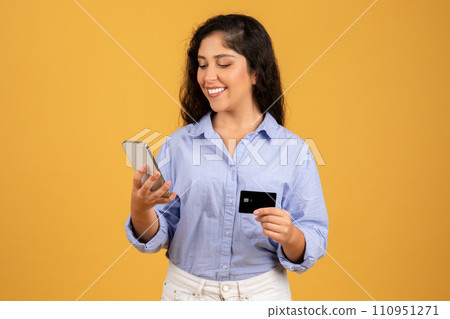 Smiling latin millennial brunette woman in casual typing on smartphone 110951271