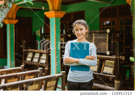 smiling young Asian businesswoman carrying clipboard smiling young Asian businesswoman carrying clipboard 110951313