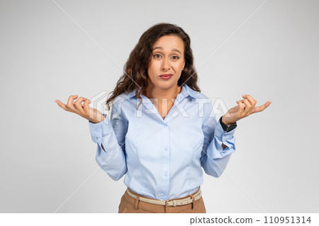 Confused millennial caucasian businesswoman in formal wear points fingers to sides at free space Confused millennial caucasian businesswoman in formal wear points fingers to sides at free space 110951314