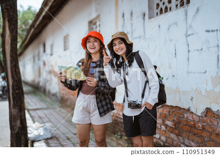 Asian girl local tourist uses a map to find the way Asian girl local tourist uses a map to find the way 110951349